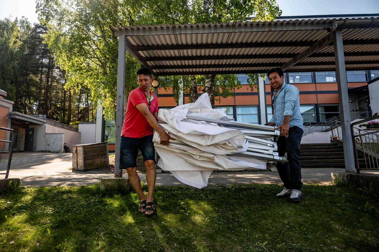 et par menn som står ved siden av et stort hvitt stofflaken