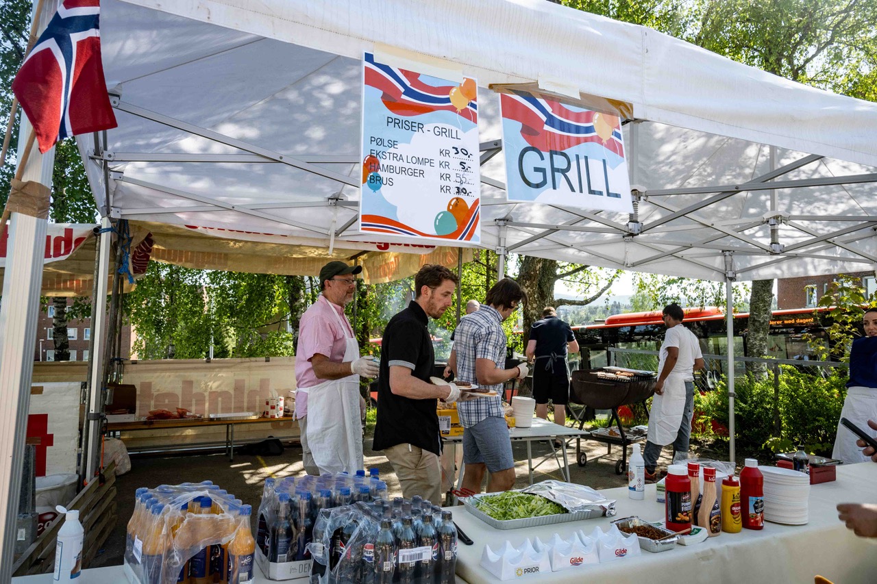 en gruppe mennesker som står under et telt med mat og drikke