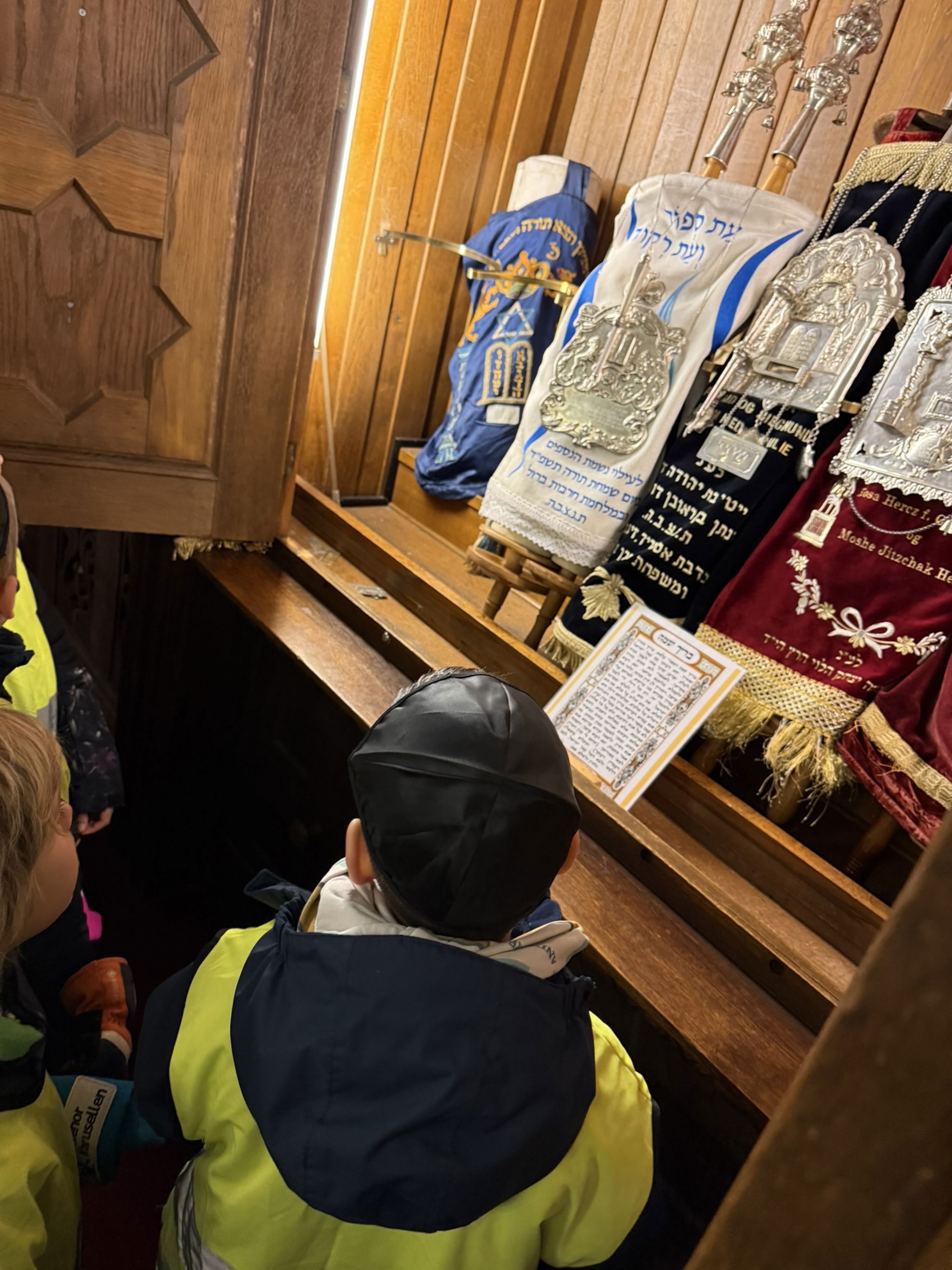 en gruppe mennesker som sitter ved et bord med bøker og en veske