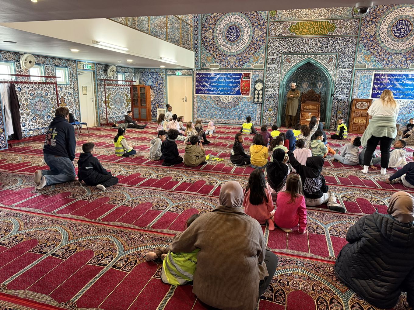 en gruppe mennesker som sitter på gulvet i et rom