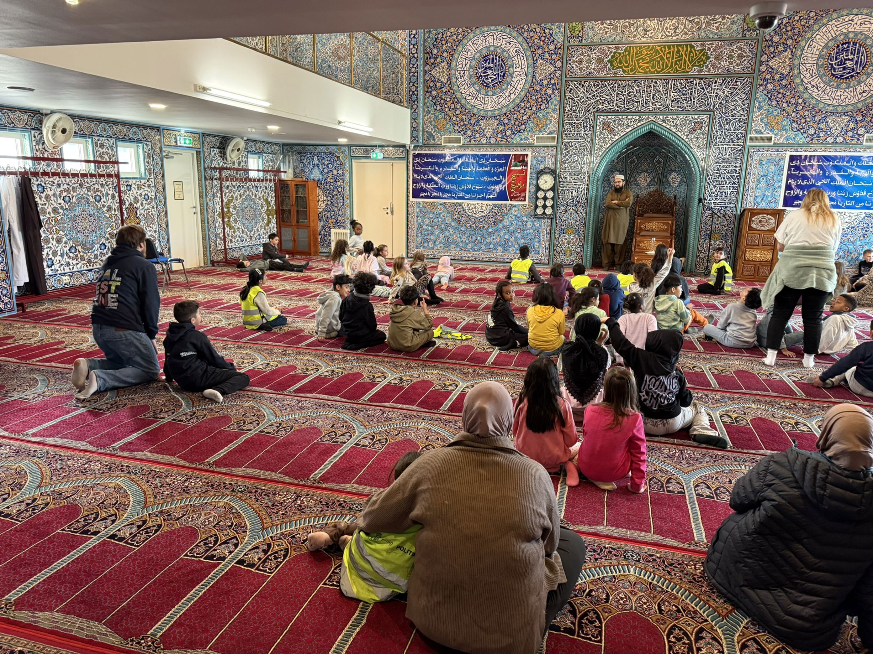 en gruppe mennesker som sitter på gulvet i et rom