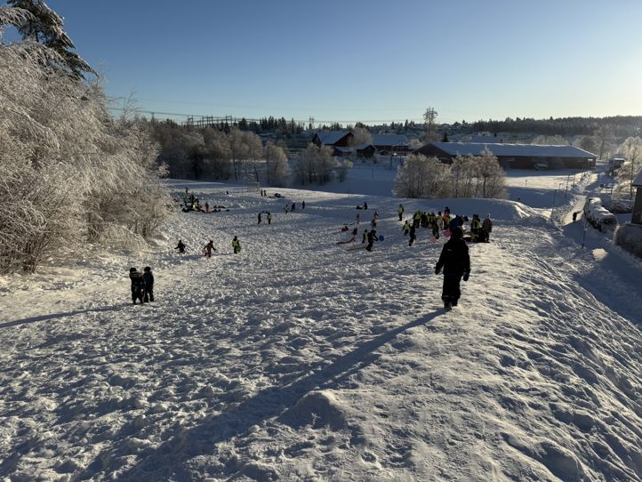 En gruppe mennesker på en snødekt bakke