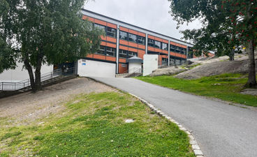 En bygning med vei og trær