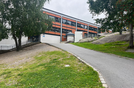 En bygning med vei og trær