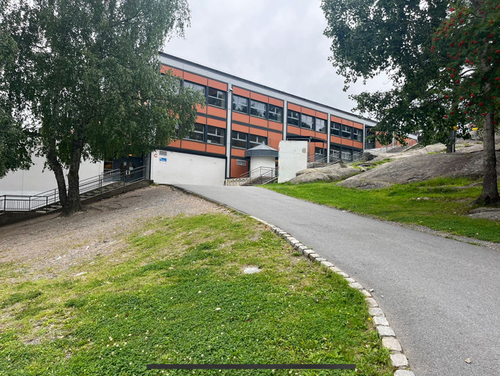 En bygning med vei og trær En bygning med vei og trær